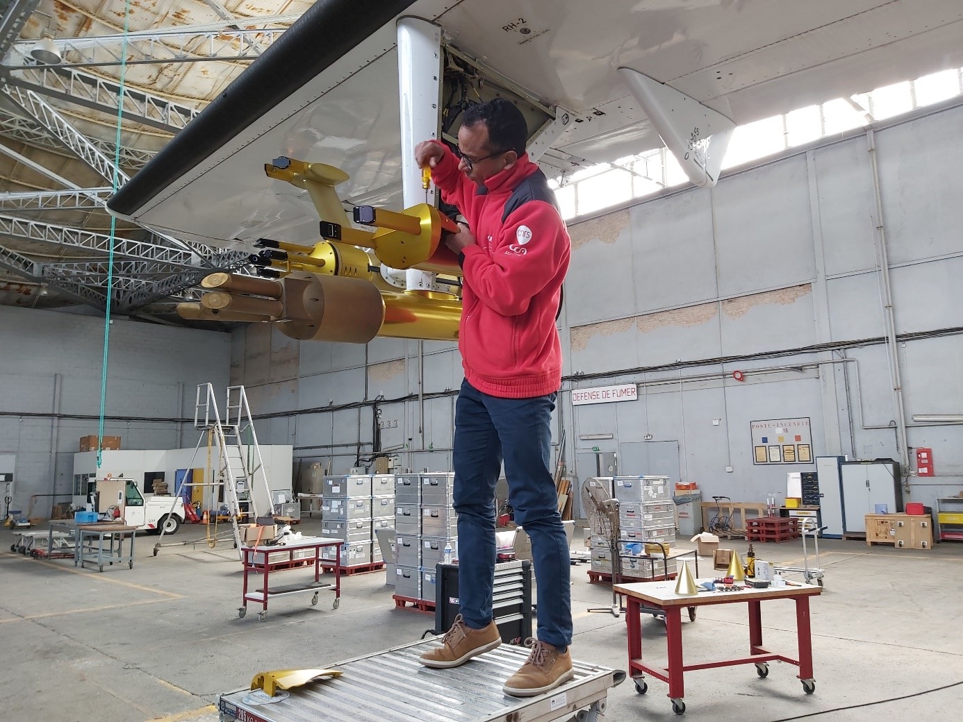 Thierry Latchimy finalise l'installation de la sonde HVPS installée sous l'aile de l'ATR-42 de SAFIRE